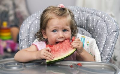 Happy Baby Girl Eating Watermelon In High Chair Toronto Children S Therapy Center